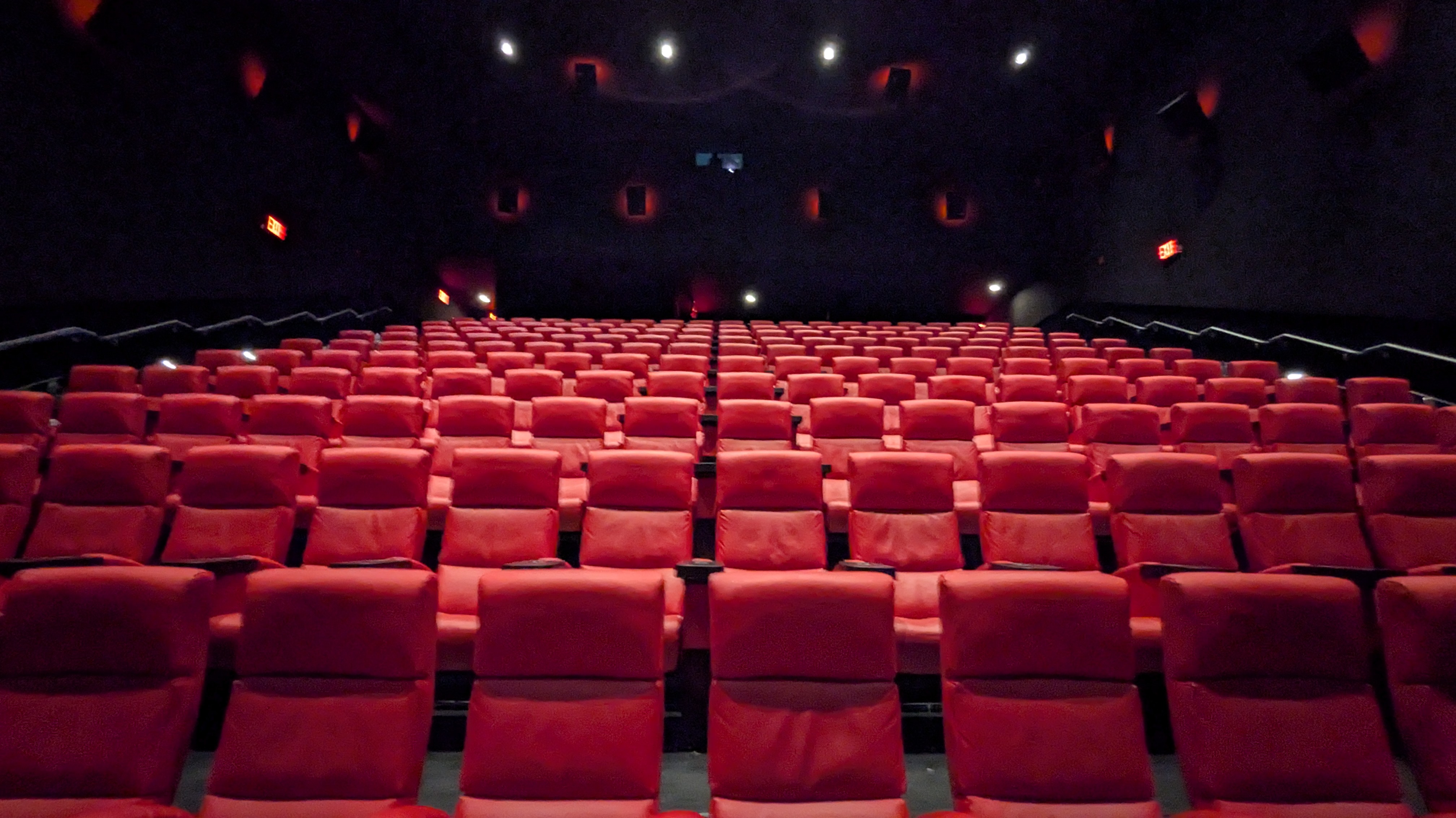 Filas de butacas rojas en una sala de cine vacía